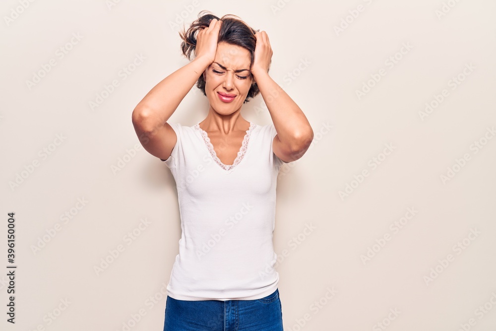 Young beautiful woman wearing casual clothes suffering from headache desperate and stressed because pain and migraine. hands on head. Young beautiful woman wearing casual clothes suffering from headache desperate and stressed because pain and migraine. hands on head.