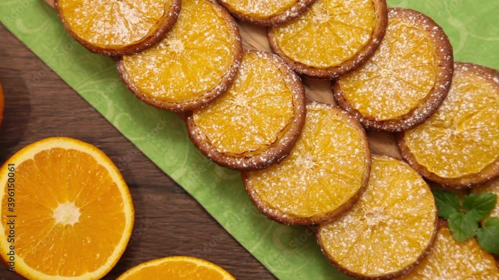 a beautiful cookie with oranges lies on a green tablecloth a beautiful cookie with oranges lies on a green tablecloth
