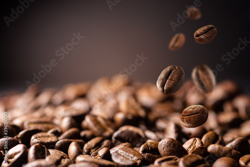 Coffee beans at the fabrique. Coffee beans fall on the table. Background made of falling down fresh coffee beans with copy space