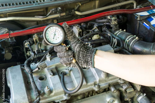 Auto mechanic use compression meter to measure car cylinder compression, Car maintenance service.