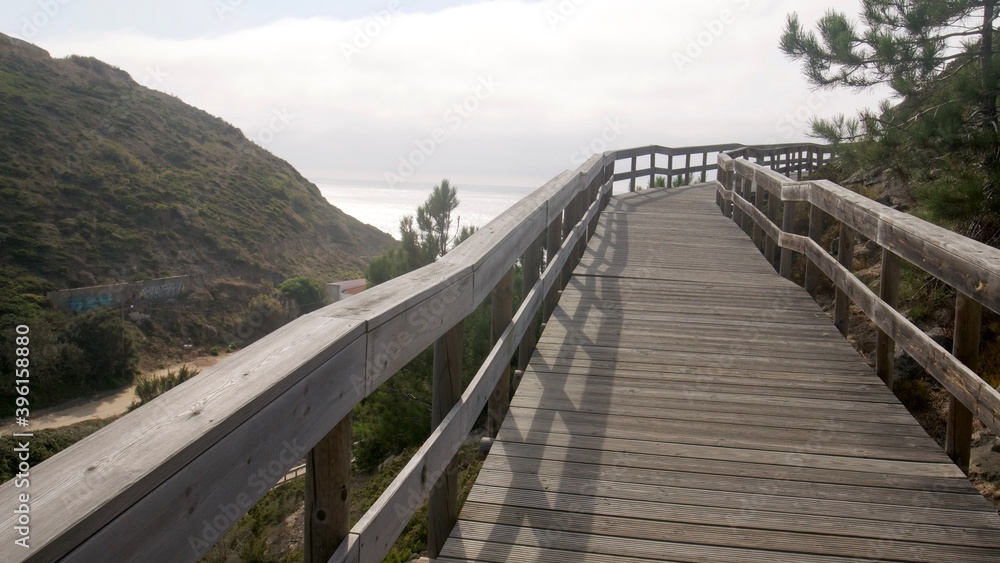  Wooden walk to the beach on a side of a hill in Portugal