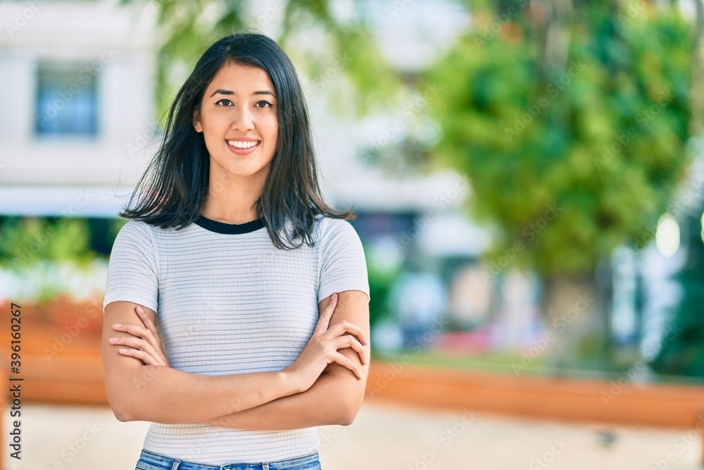 Young hispanic woman with crossed arms smiling happy at the park. Young hispanic woman with crossed arms smiling happy at the park.
