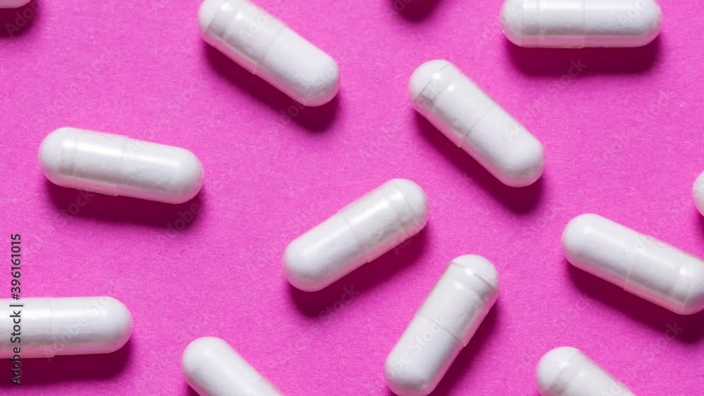 Animates stop motion texture white pile capsules on pink background Animates stop motion texture white pile capsules on pink background