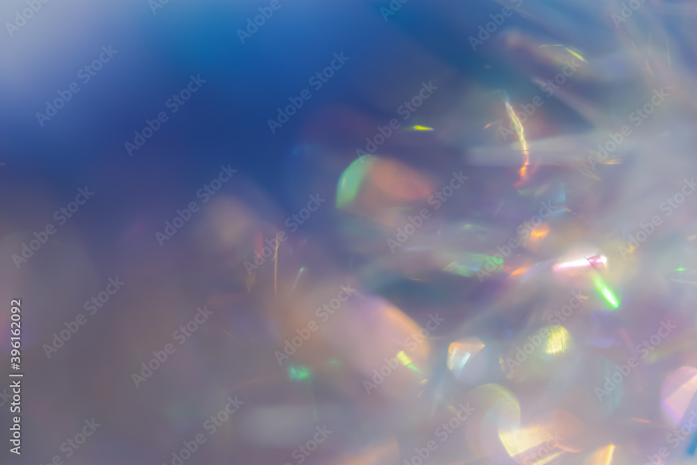 Abstract holiday background made of multicolored bokeh. Fancy sparkling iridescent pearl with silver effect creative design for Christmas, New year, Birthday. Hologram ornament made of shiny tinsel.
