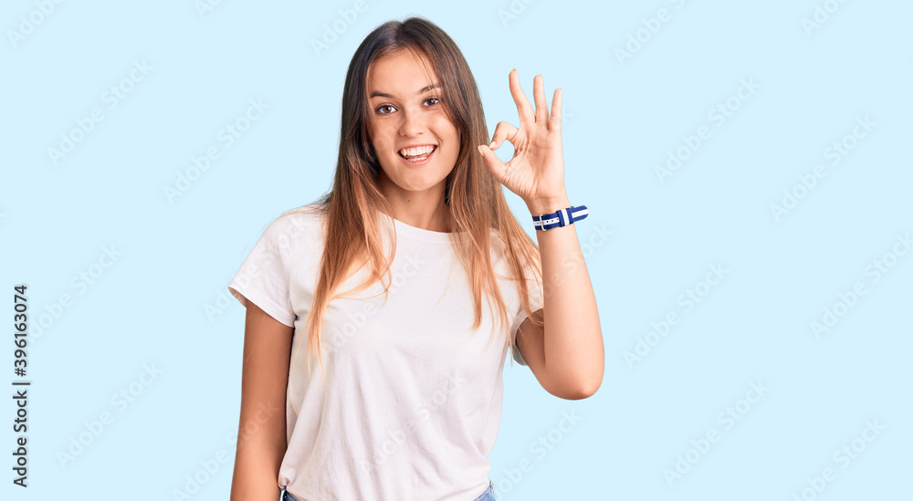 Beautiful caucasian woman wearing casual white tshirt smiling positive doing ok sign with hand and fingers. successful expression. Beautiful caucasian woman wearing casual white tshirt smiling positive doing ok sign with hand and fingers. successful expression.