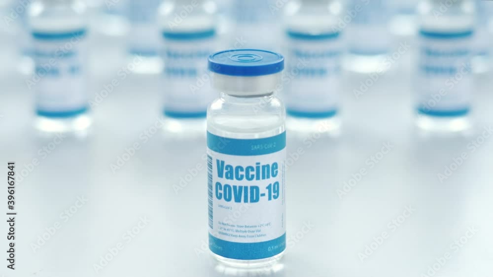 Covid 19 corona virus vaccine vial for injections among many bottles on medical pharmaceutical industry table. Coronavirus cure manufacture, flu treatment drug pharmacy production concept, close up. Covid 19 corona virus vaccine vial for injections among many bottles on medical pharmaceutical industry table. Coronavirus cure manufacture, flu treatment drug pharmacy production concept, close up.