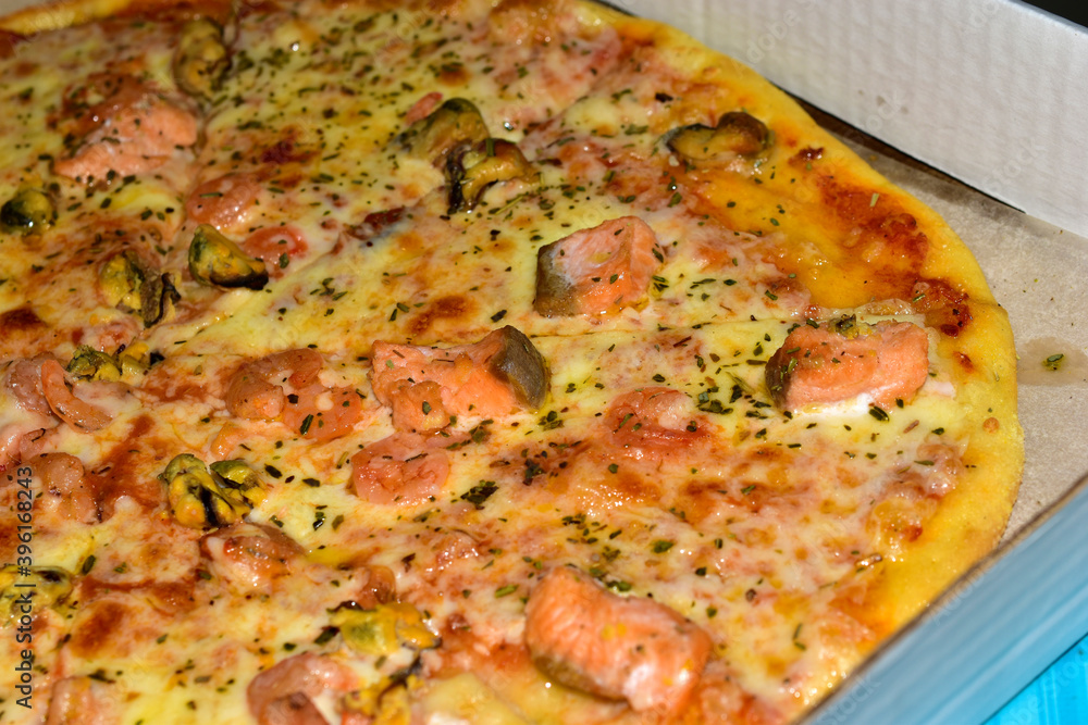 Round delicious sea pizza with seafood in a box Round delicious sea pizza with seafood in a box