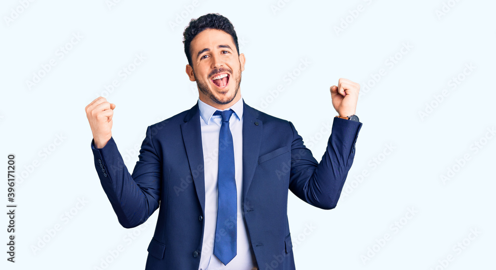 Young hispanic man wearing business clothes screaming proud, celebrating victory and success very excited with raised arms Young hispanic man wearing business clothes screaming proud, celebrating victory and success very excited with raised arms