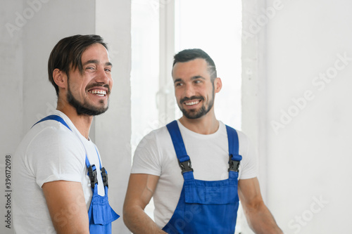 Two men in blue overalls. They are smiling