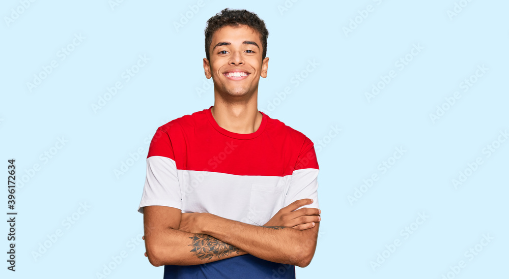 Young handsome african american man wearing casual clothes happy face smiling with crossed arms looking at the camera. positive person. Young handsome african american man wearing casual clothes happy face smiling with crossed arms looking at the camera. positive person.