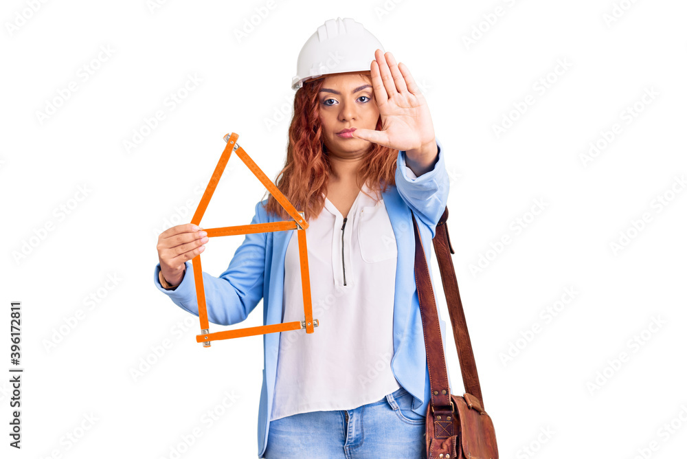 Young latin woman wearing architect hardhat with open hand doing stop sign with serious and confident expression, defense gesture Young latin woman wearing architect hardhat with open hand doing stop sign with serious and confident expression, defense gesture