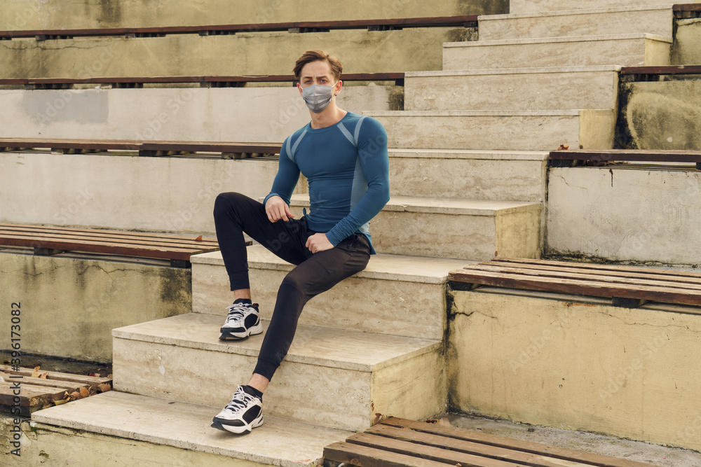 Athletic and handsome young male wearing a gray mask. Young athlete wearing a mask to train outside. Fit muscular sportsman dressed in sportswear wearing a gray mask. Athletic and handsome young male wearing a gray mask. Young athlete wearing a mask to train outside. Fit muscular sportsman dressed in sportswear wearing a gray mask.