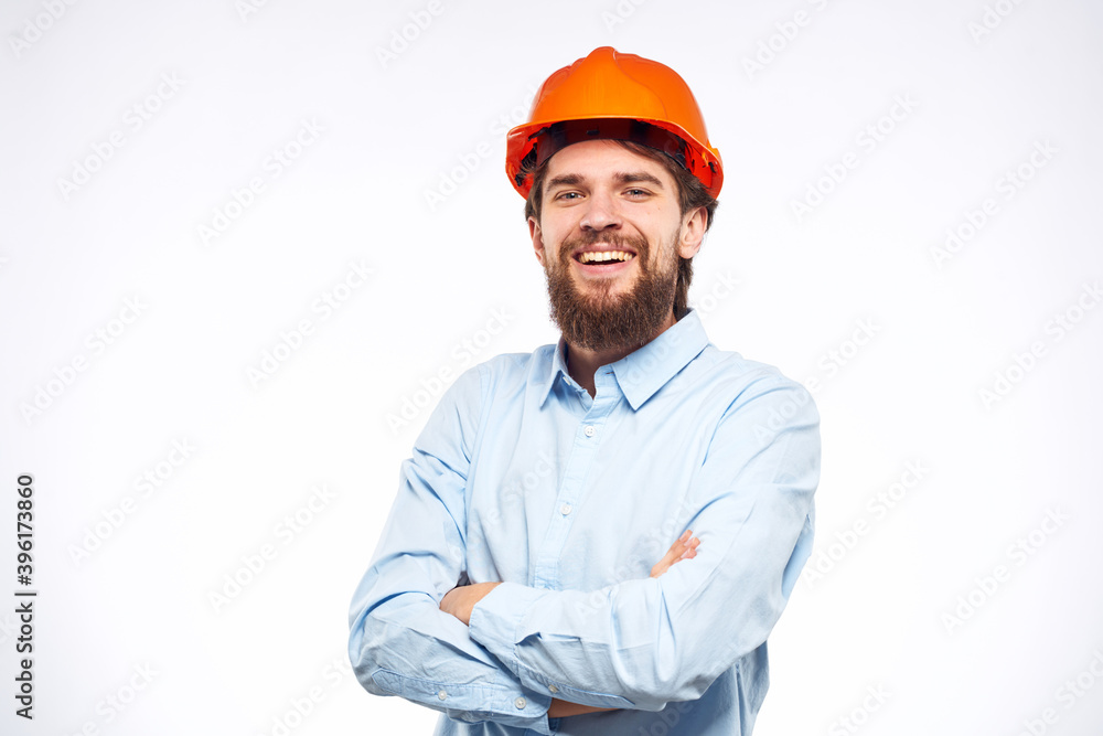 Cheerful man orange hard hat work industry professional lifestyle light background Cheerful man orange hard hat work industry professional lifestyle light background