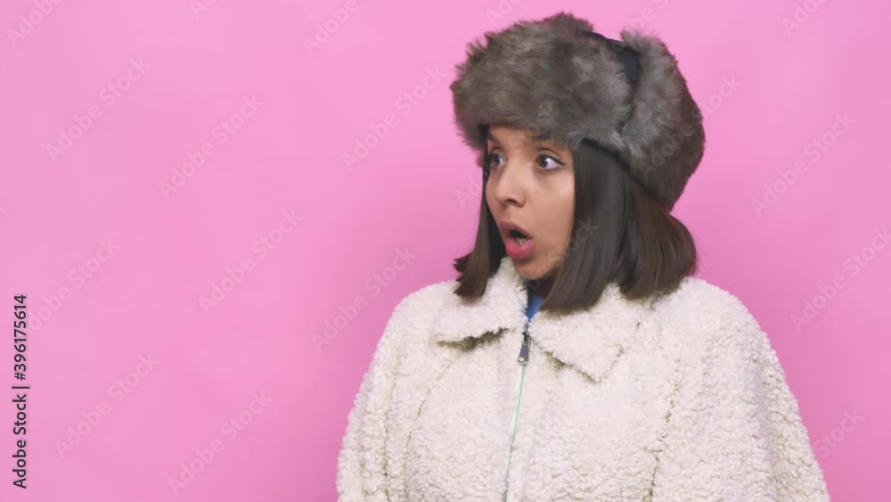 Young hispanic woman wearing a winter hat face closeup who feels sad and pensive, looking at copy space Young hispanic woman wearing a winter hat face closeup who feels sad and pensive, looking at copy space
