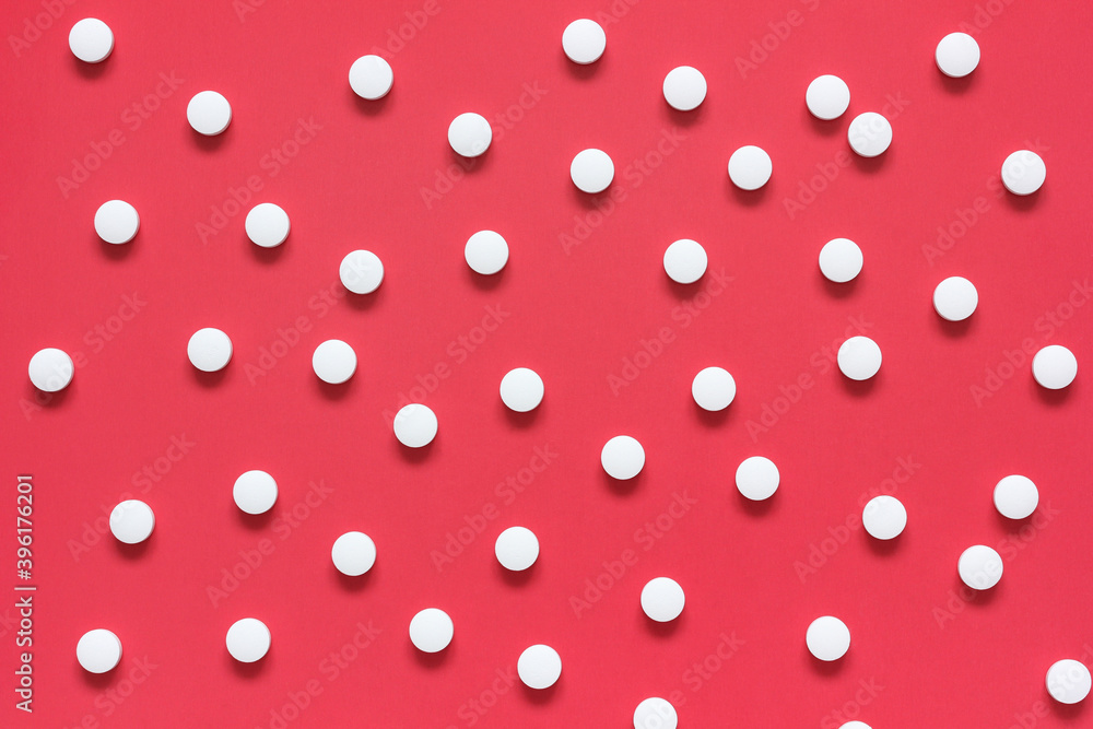 white round tablets on a red background, flat lay. white round tablets on a red background, flat lay.