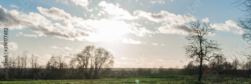 tillage agricultural field in spring time under blue sky with bright sunlight