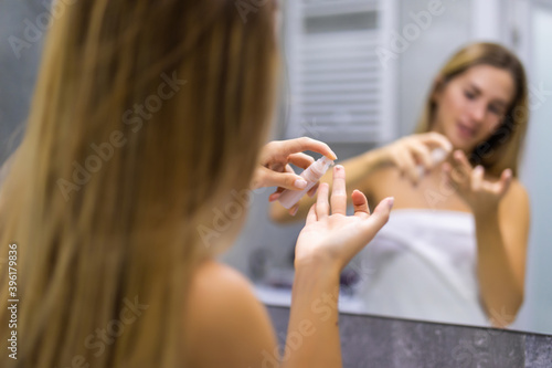Woman applying concealer on face. Macro shot of attractive woman who is painting skin under her eyes with concealer cream. Make-up artist  beauty  body care  preparation of date or celebration concept