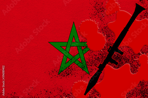 Morocco flag and black RPG-7 rocket-propelled grenade launcher in red blood. Concept for terror attack or military operations with lethal outcome photo