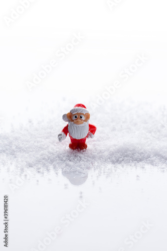 Santa Claus on a white background in the snow under clipping. Vertical orientation. Copy space. Empty space. The concept of a new year. Christmas wish toy in a snowdrift
