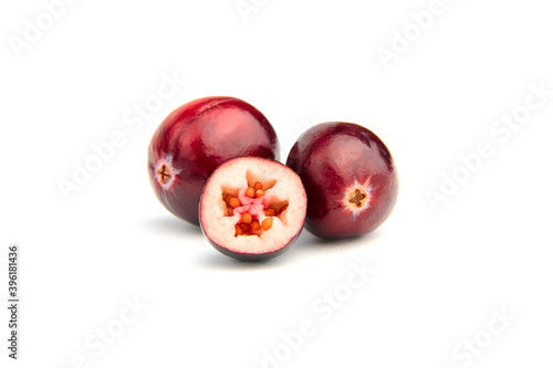 Halves and whole fresh red fall cranberries isolated on white photo