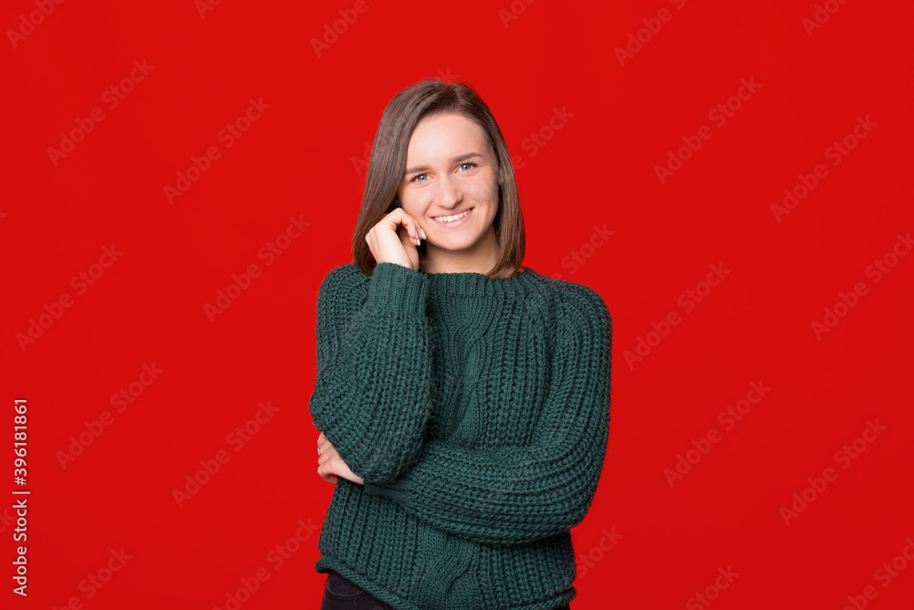 Young smiling woman in gray sweater posing at camera with toothy smiling, standing over isolated background. Young smiling woman in gray sweater posing at camera with toothy smiling, standing over isolated background.