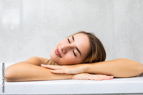 Portrait of young woman relaxing in bathtub at home