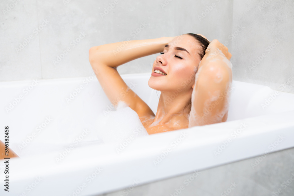 Young beautiful woman is relaxing in the bath with a foam Young beautiful woman is relaxing in the bath with a foam
