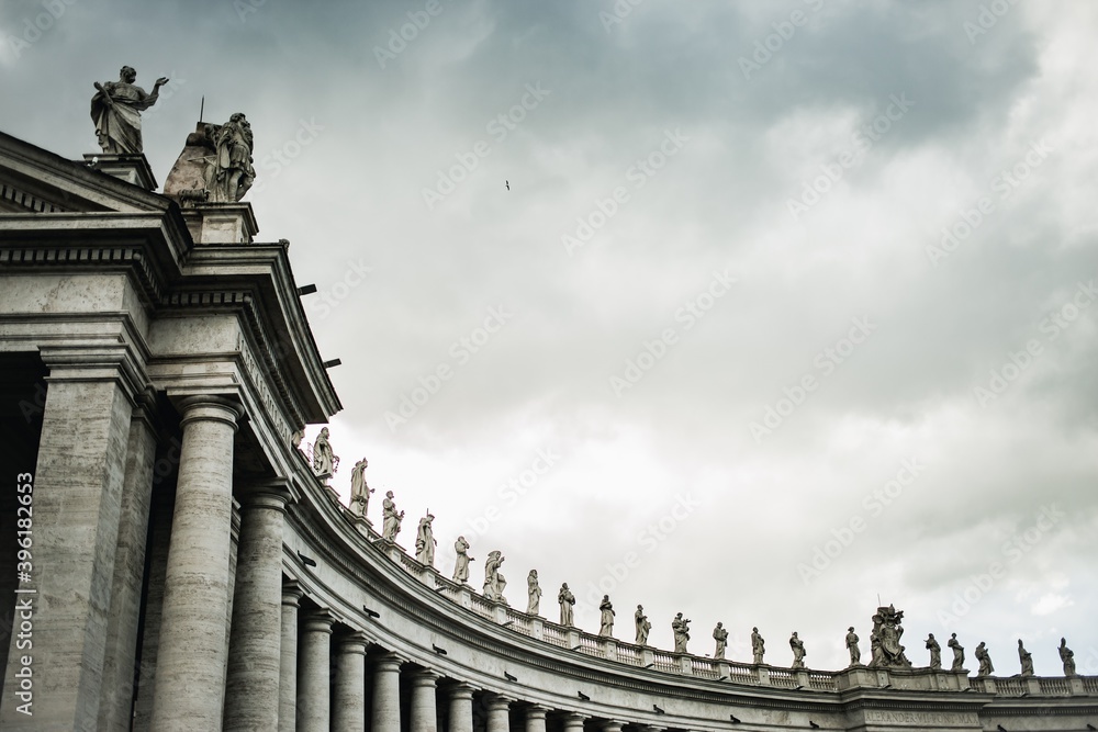 Curved view of ancient statues  on top of pillars in the courtyard of St. Peter's Basilica at the Vatican in Rome