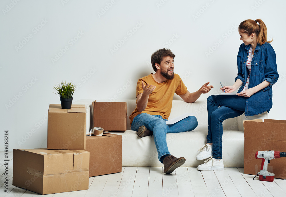 Married couple in new apartment moving boxes with joy things Married couple in new apartment moving boxes with joy things