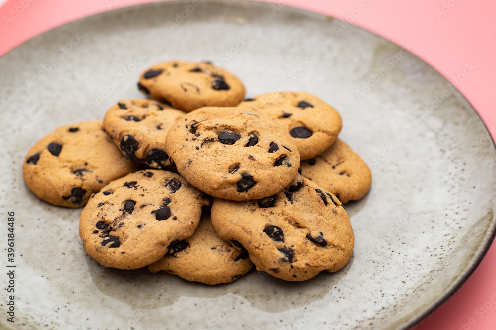 Cookies with chocolate on a plate on a pink background. Cookies with chocolate on a plate on a pink background.