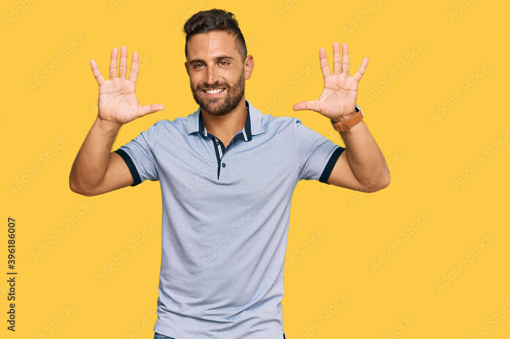Handsome man with beard wearing casual clothes showing and pointing up with fingers number ten while smiling confident and happy. Handsome man with beard wearing casual clothes showing and pointing up with fingers number ten while smiling confident and happy.