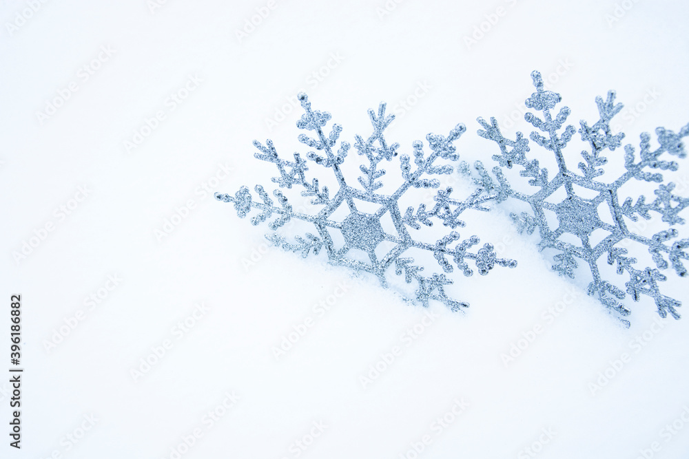 Snowflakes in the snow. Christmas snowy background with a pair of snowflakes. Christmas background.