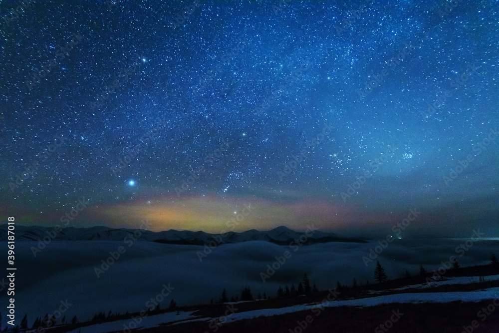 Space starry nights with a bright Milky Way on the backdrop of tourists with tents.