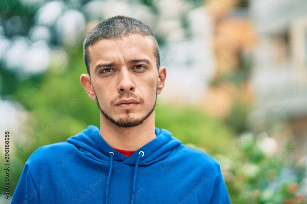 Young hispanic man with serious expression standing at the city. Young hispanic man with serious expression standing at the city.