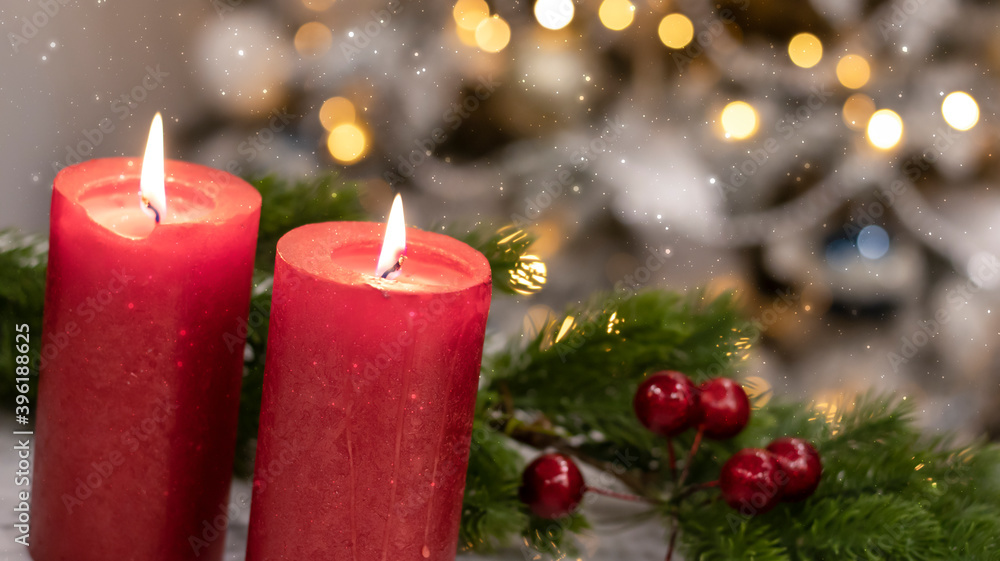 Red candles on the background of the Christmas tree with New Year's lights. Christmas festive background, fir tree with bokeh lights. Red candles on the background of the Christmas tree with New Year's lights. Christmas festive background, fir tree with bokeh lights.