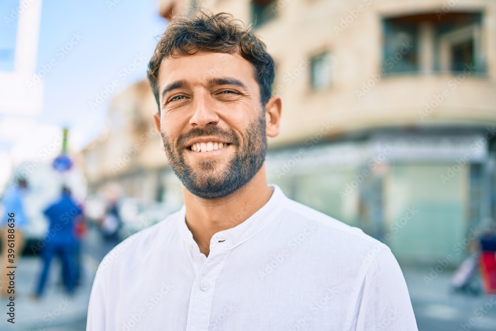 Handsome man with beard wearing casual white shirt on a sunny day smiling happy outdoors Handsome man with beard wearing casual white shirt on a sunny day smiling happy outdoors