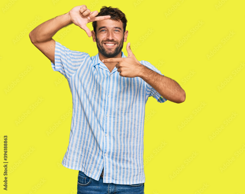 Handsome young man with beard wearing casual fresh shirt smiling making frame with hands and fingers with happy face. creativity and photography concept. Handsome young man with beard wearing casual fresh shirt smiling making frame with hands and fingers with happy face. creativity and photography concept.