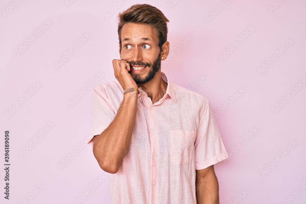 Handsome caucasian man with beard wearing casual pink shirt looking stressed and nervous with hands on mouth biting nails. anxiety problem. Handsome caucasian man with beard wearing casual pink shirt looking stressed and nervous with hands on mouth biting nails. anxiety problem.