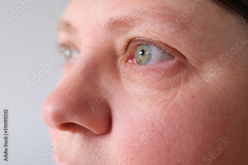 close up eyes elderly woman opening blinking macro beauty, fine wrinkles on the face, spots, the concept of cosmetic anti-aging procedures, facial massage