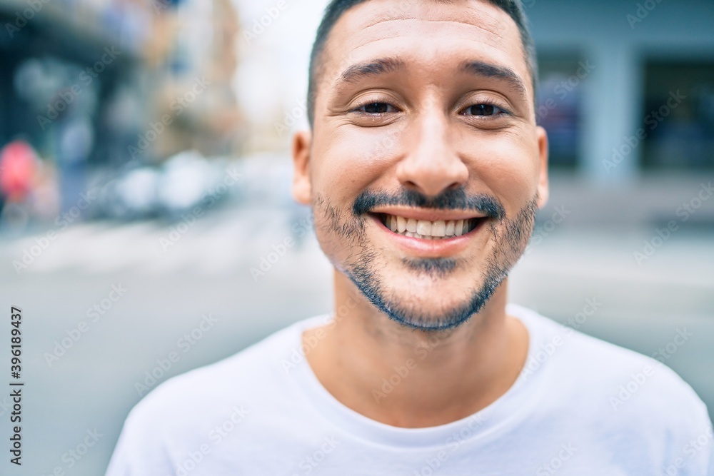 Young hispanic man smiling happy walking at street of city. Young hispanic man smiling happy walking at street of city.