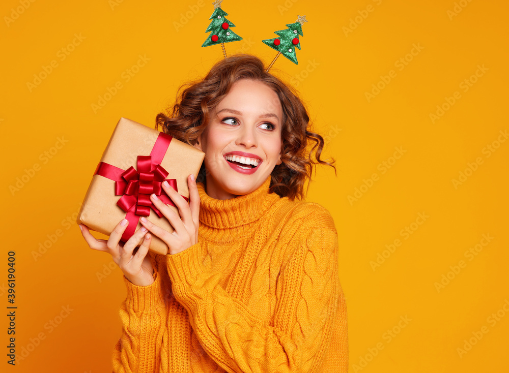 Glad young female with Christmas gift. Glad young female with Christmas gift.