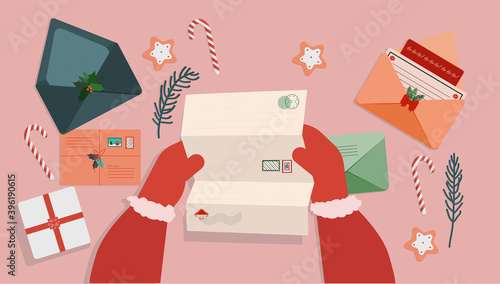 at the table with New Year's and Christmas letters Santa Claus reads letters with requests for a gift
