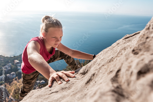 Obraz na plátne Purposeful young girl climbs to top of mountain
