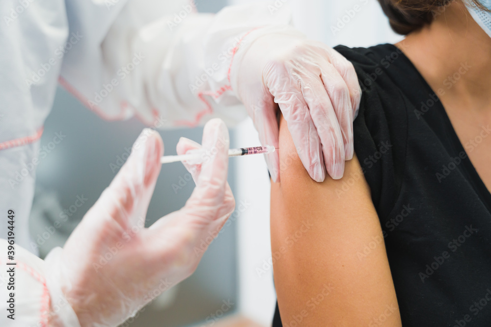 COVID-19 coronavirus vaccine. Doctor putting a vaccine to the patient against Covid 19 COVID-19 coronavirus vaccine. Doctor putting a vaccine to the patient against Covid 19