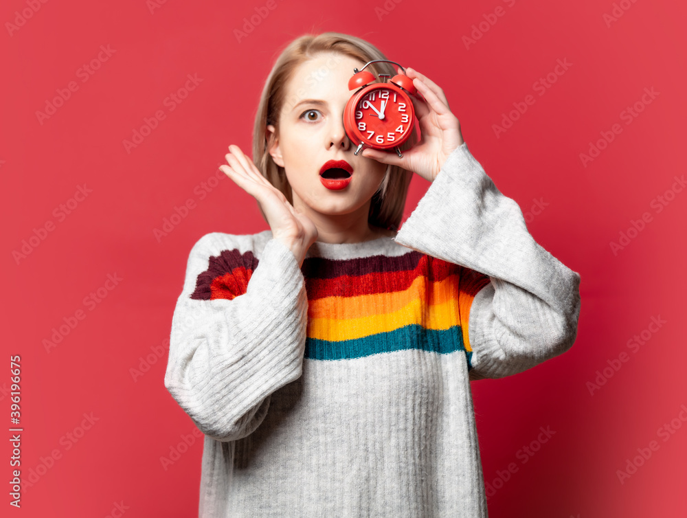 Beautiful blonde in sweater with alarm clock Beautiful blonde in sweater with alarm clock