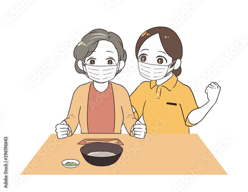 お粥を食べる高齢女性　女性介護士　マスク