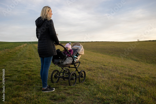 Frau mit Kinderwagen auf Feld