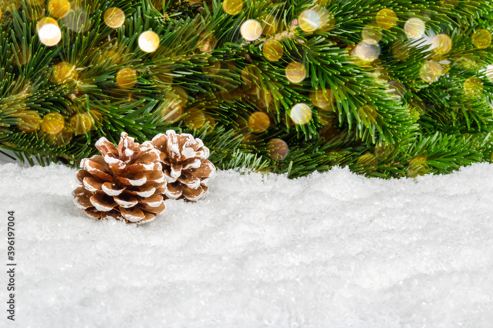 Christmas background for product presentation with pine cones in snow under fir tree. Pine branches and bokeh lights as festive winter composition with space for product placement