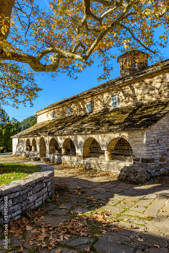 Taxiarchon stone built church during fall season in the picturesque village of Mikro papigo in Epirus zagori greece