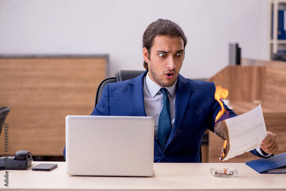 Young male employee burning papers in the office Young male employee burning papers in the office